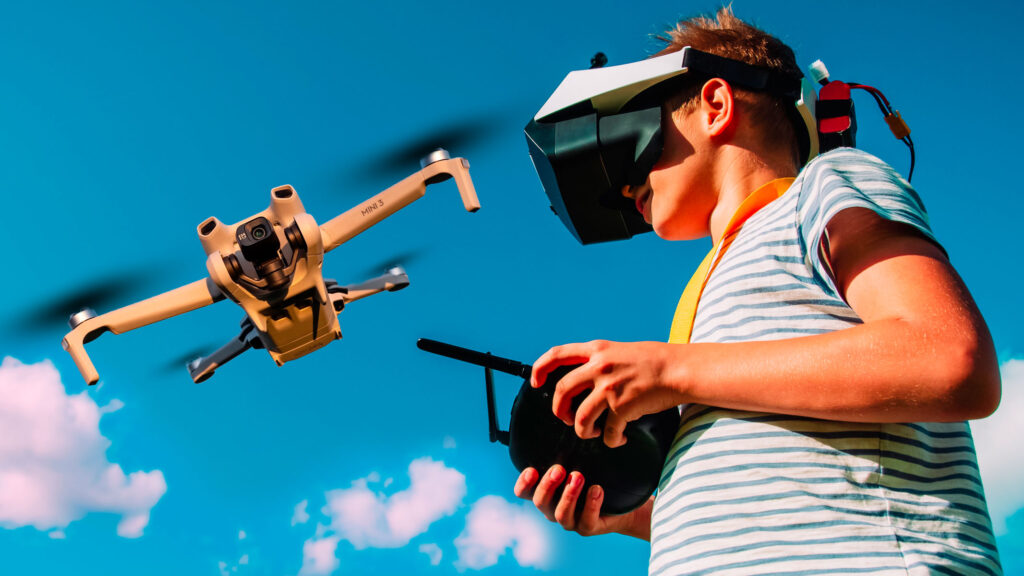 A kind operating a drone with a remote control and VR headset