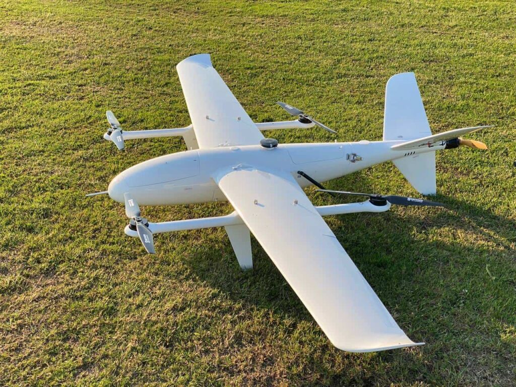 A long range VTOL drone sitting in grass