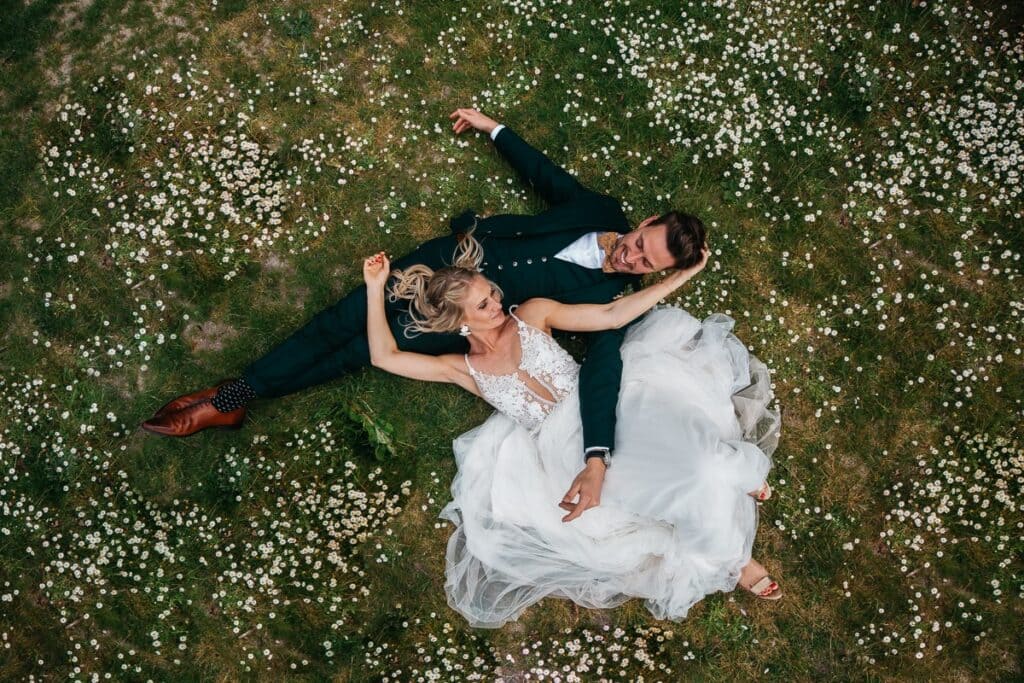 a couple lying on the ground an aerial shot being taken using drone