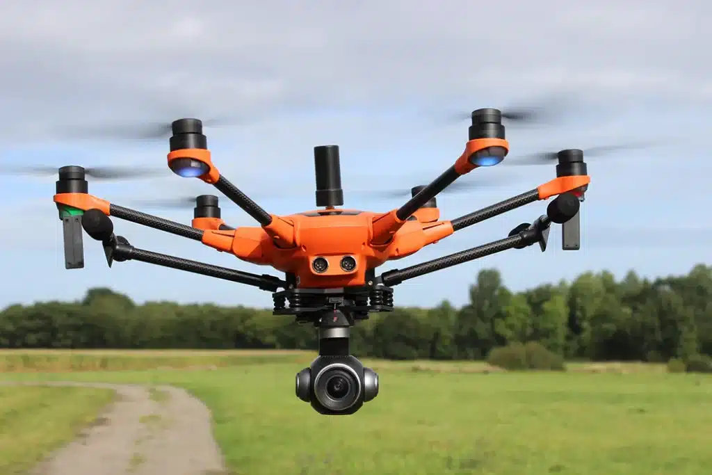 yuneec orange colored drone flying above a field