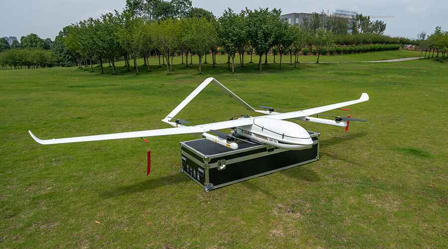 A view of a large white gas drone over a black chest in a field