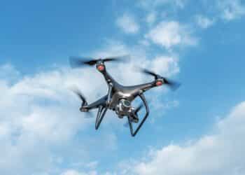 A Black Modern Drone With A Camera Flies In The